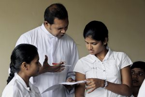 A Salesian teacher helps in the girls' class of the school.